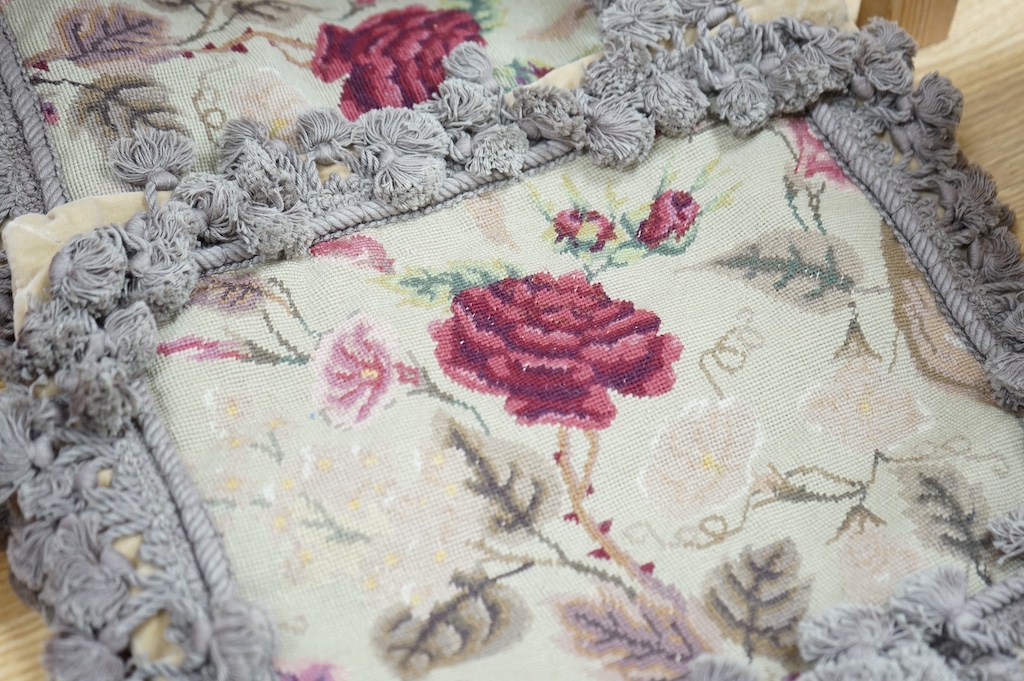 Six small wool worked rectangular cushion covers, designed with roses and trailing flowers on a pale green ground, with mushroom tasselled fringing and velvet backs. 30cm wide x 26cm high. Condition - unused